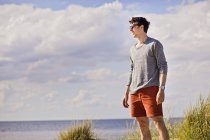 Young man standing on shore — Stock Photo