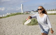 Счастливая женщина играет в теннис — стоковое фото