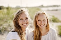 Happy female friends enjoying at beach — Stock Photo