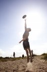Young man reaching for flying disc — Stock Photo