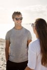 Man talking with female friend at beach — Stock Photo