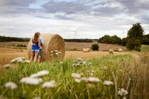 Couple standing by hay bale — Stock Photo