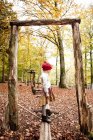 Girl standing on log in forest — Stock Photo