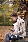 Женщина с помощью смартфона, сидя на скале — стоковое фото