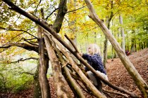 Mädchen baut Baumstamm-Zelt im Wald — Stockfoto