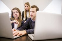 Jóvenes empresarios que utilizan ordenador portátil - foto de stock