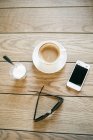 Taza de café con teléfono inteligente roto - foto de stock