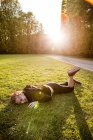Спортсмен лежит на траве — стоковое фото