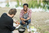 Happy male friends barbecuing — Stock Photo