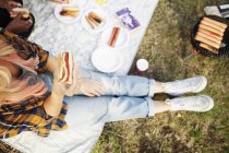 Donna che tiene hot dog durante il picnic — Foto stock