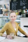 Donna seduta a tavola in caffetteria — Foto stock