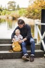 Man and baby girl searching something in bag — Stock Photo