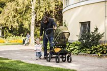 Vater und Baby laufen mit Kinderwagen im Park — Stockfoto
