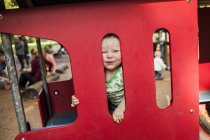 Мальчик смотрит сквозь миниатюрный поезд — стоковое фото