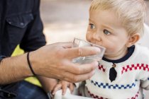 Padre che nutre acqua alla bambina — Foto stock