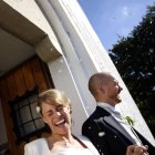Fröhliche Frischvermählte gehen im Konfettiregen vor die Kirche — Stockfoto