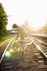 Жінка з собакою на залізничних коліях — стокове фото