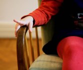 Menina sentada na cadeira em casa — Fotografia de Stock