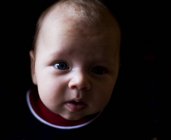 Portrait de mignon bébé garçon sur noir — Photo de stock