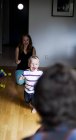 Smiling boy running while playing with parents at home — Stock Photo