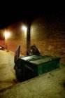 Lata de lixo na rua à noite — Fotografia de Stock