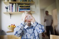 Boy drinking from glass in home interior — Stock Photo