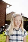 Blondes Mädchen steht an sonnigem Tag im Hinterhof — Stockfoto