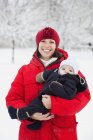 Mulher feliz carregando bebê menino — Fotografia de Stock