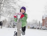 Ragazzo inginocchiato da palo di legno nella neve — Foto stock