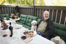 Старший мужчина сидит с собакой — стоковое фото