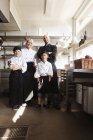 Сім'я шеф-кухарів, що стоїть в ресторані — стокове фото
