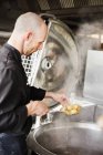 Шеф-кухар смажить картоплю в контейнері — стокове фото