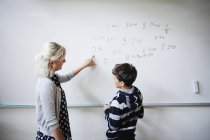 Lehrer erklärt Schüler Whiteboard — Stockfoto