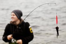 Uomo con canna da pesca nel lago — Foto stock