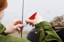 Adolescente aplicando gancho na linha de pesca — Fotografia de Stock