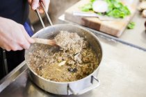 Koch mixt Essen in der Großküche — Stockfoto