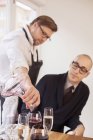 Koch serviert dem Kunden Rotwein — Stockfoto