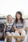 Madre e figlia sedute insieme sul divano di casa — Foto stock
