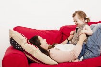 Chica sentado en madres estómago - foto de stock