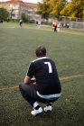 Player crouching while watching soccer — Stock Photo