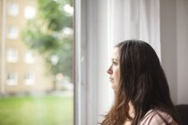 Frau gegen Fenster — Stockfoto