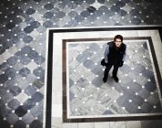 Young man standing on tiled floor — Stock Photo