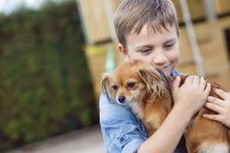 Felice ragazzo che abbraccia Chihuahua — Foto stock