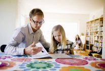 Vater hilft Tochter bei Hausaufgaben zu Hause — Stockfoto