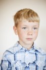 Ritratto di ragazzo biondo con lentiggini contro il muro a casa — Foto stock