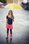 Mujer feliz bajo paraguas amarillo - foto de stock