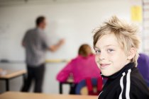 Retrato de menino sentado em sala de aula — Fotografia de Stock