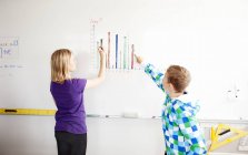 Boy and girl drawing chart — Stock Photo