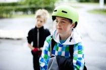 Menino usando capacete com amigo — Fotografia de Stock