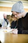 Students writing in classroom at university — Stock Photo